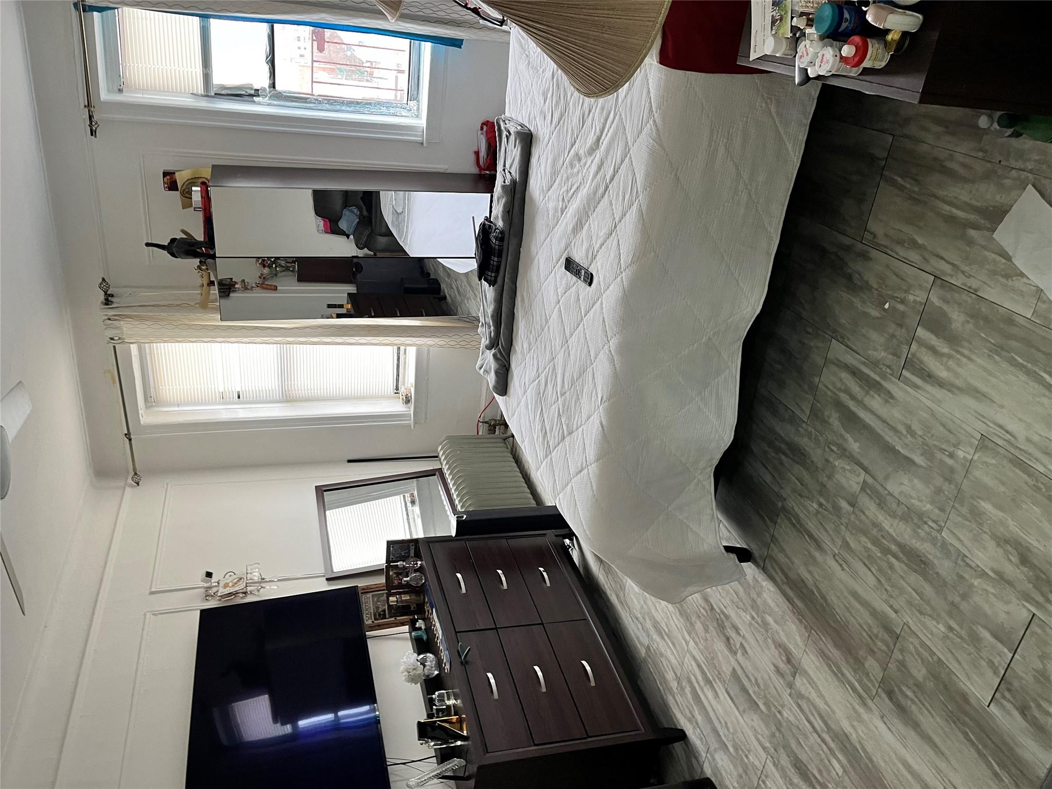 39-82 65th Place, Unit 4F Queens, NY 11377 - Photo 9 of 10 a bedroom with a bed and flat screen tv