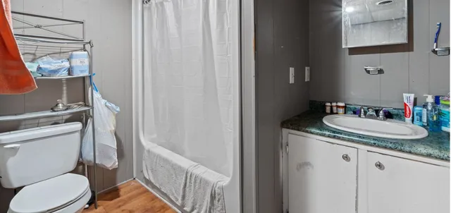 a bathroom with a granite countertop sink toilet and mirror