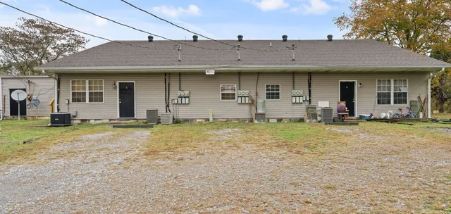 a view of a house with backyard and a tree