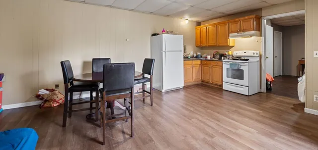 a kitchen with a table chairs refrigerator and cabinets