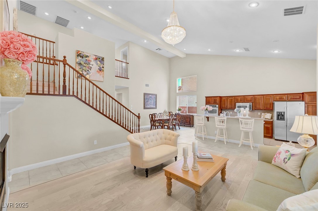 9725 Sandy Turtle Avenue Las Vegas, NV 89149 - Photo 13 of 51 Living area with high vaulted ceiling, light tile patterned floors, stairway, recessed lighting, and beam ceiling