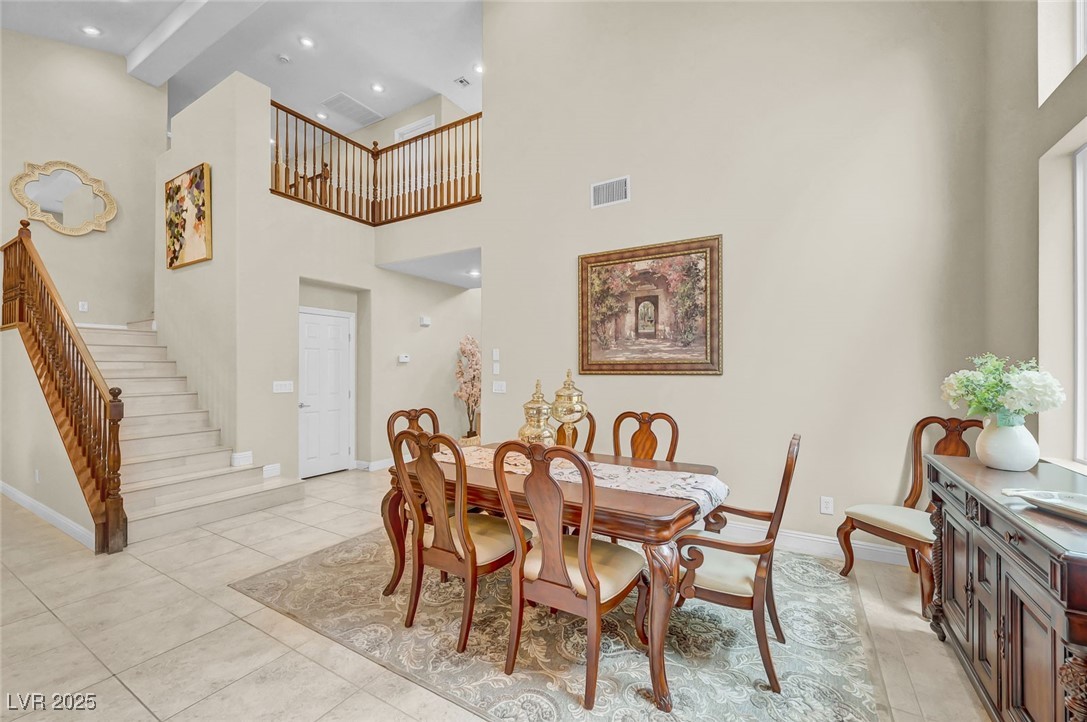 9725 Sandy Turtle Avenue Las Vegas, NV 89149 - Photo 14 of 51 Dining space with a high ceiling, stairway, and light tile patterned floors