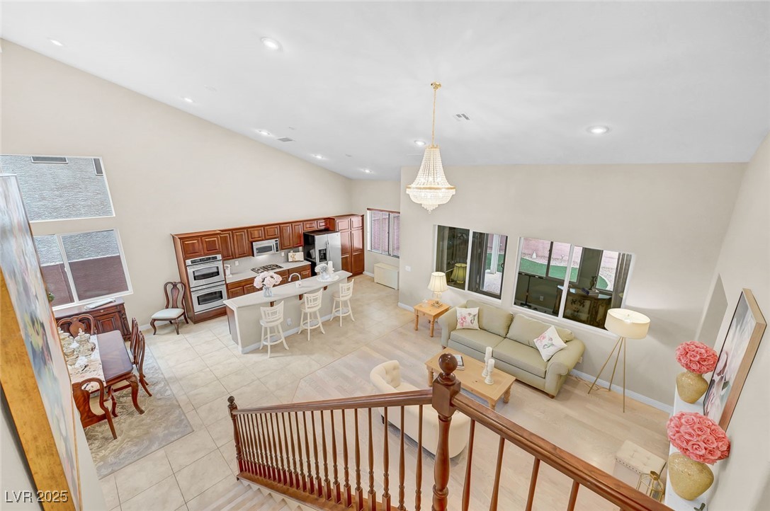 9725 Sandy Turtle Avenue Las Vegas, NV 89149 - Photo 27 of 51 Living room with high vaulted ceiling, a chandelier, recessed lighting, and light tile patterned floors