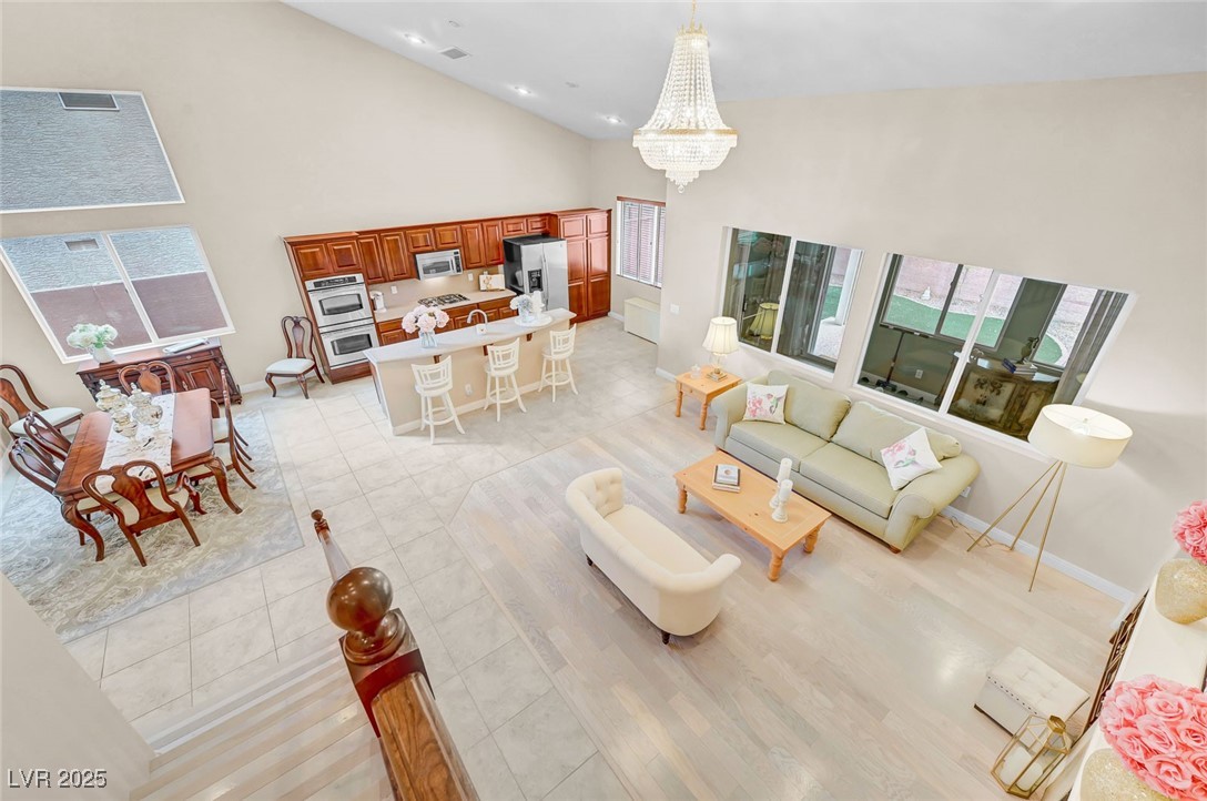 9725 Sandy Turtle Avenue Las Vegas, NV 89149 - Photo 28 of 51 Living room featuring high vaulted ceiling, plenty of natural light, a chandelier, light tile patterned floors, and recessed lighting