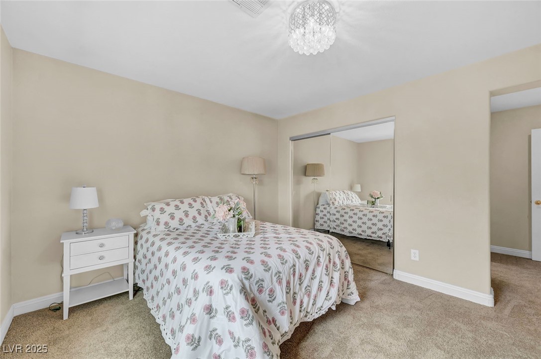 9725 Sandy Turtle Avenue Las Vegas, NV 89149 - Photo 39 of 51 Bedroom with light carpet, a closet, and a chandelier