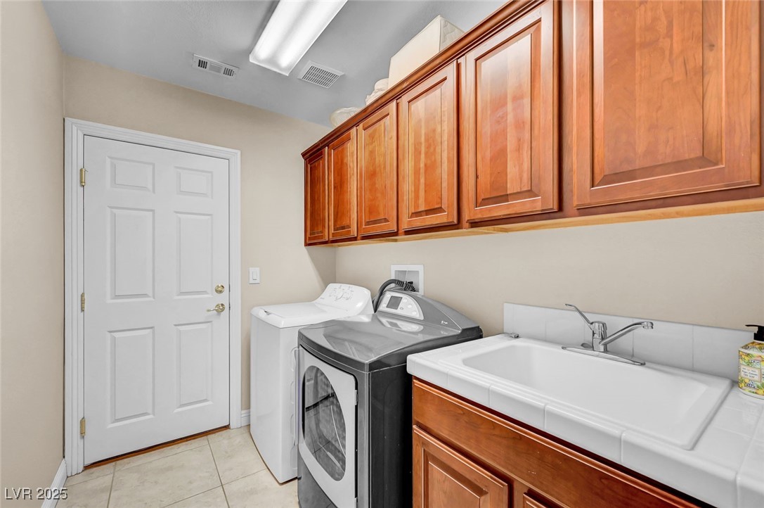 9725 Sandy Turtle Avenue Las Vegas, NV 89149 - Photo 47 of 51 Laundry room featuring light tile patterned floors, cabinet space, and washing machine and clothes dryer