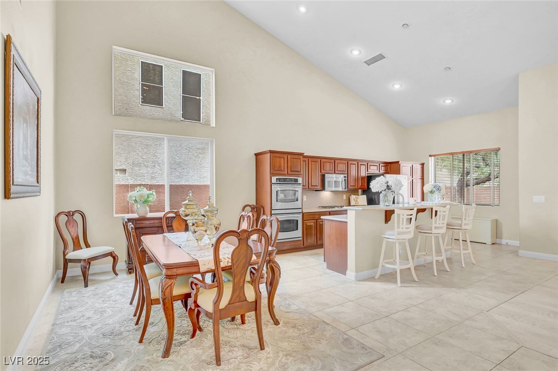 9725 Sandy Turtle Avenue Las Vegas, NV 89149 - Photo 7 of 51 Dining room featuring high vaulted ceiling, recessed lighting, and light tile patterned floors