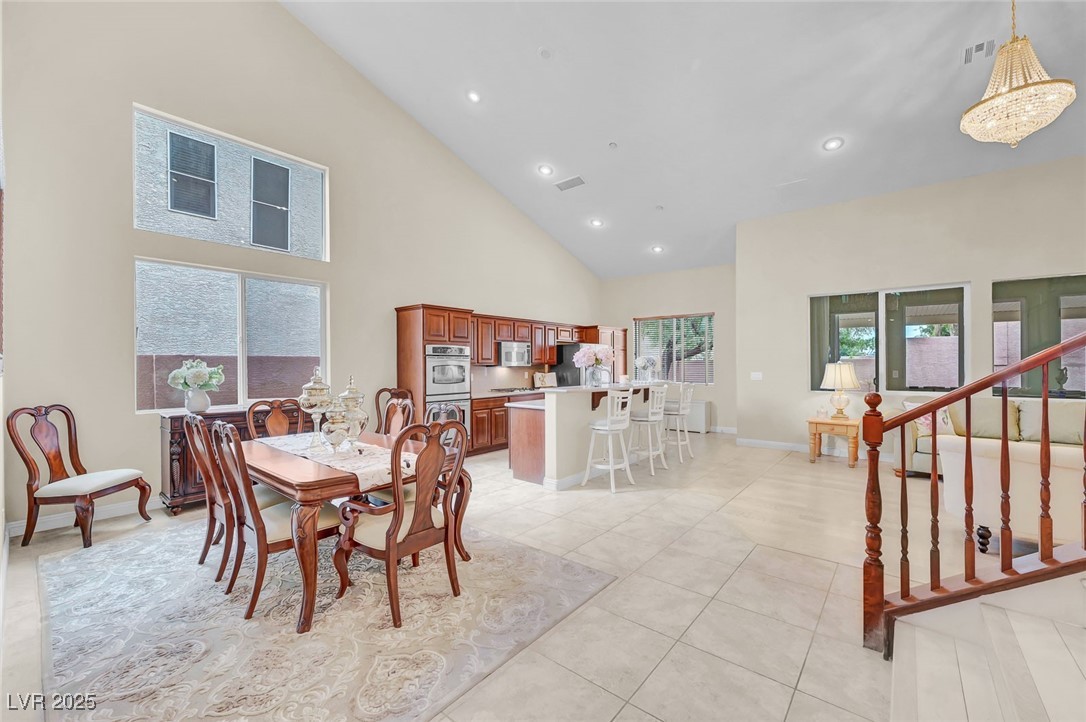 9725 Sandy Turtle Avenue Las Vegas, NV 89149 - Photo 10 of 51 Dining space featuring high vaulted ceiling, recessed lighting, stairway, and light tile patterned flooring