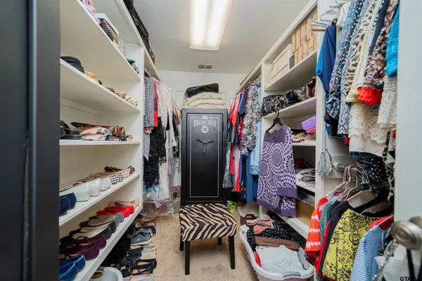 a view of walk in closet with clothes and shoes