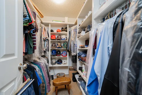 a view of walk in closet with clothes and shoes
