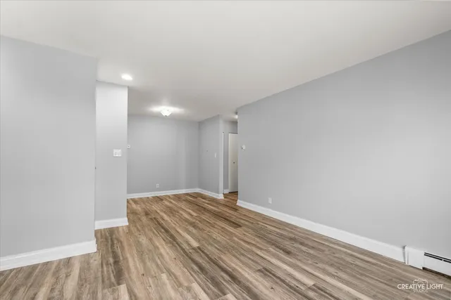 a view of a big room with wooden floor and a window