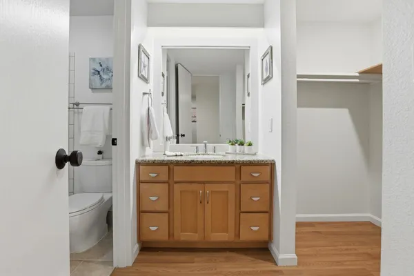 a bathroom with a granite countertop sink a mirror a shower and a bathtub
