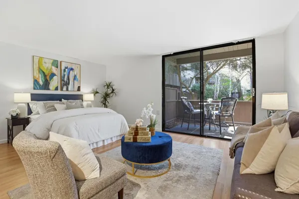 a bedroom with a bed a couch and a large window