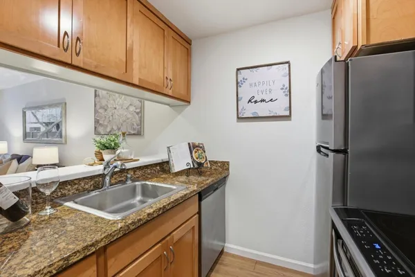 a kitchen with stainless steel appliances granite countertop a sink stove and refrigerator