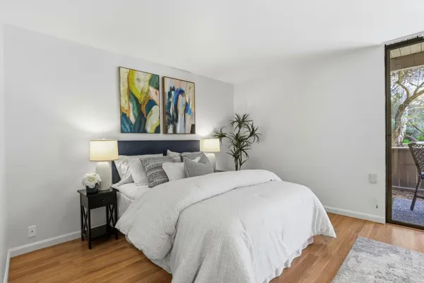 a bedroom with a large bed a chandelier and a potted plant