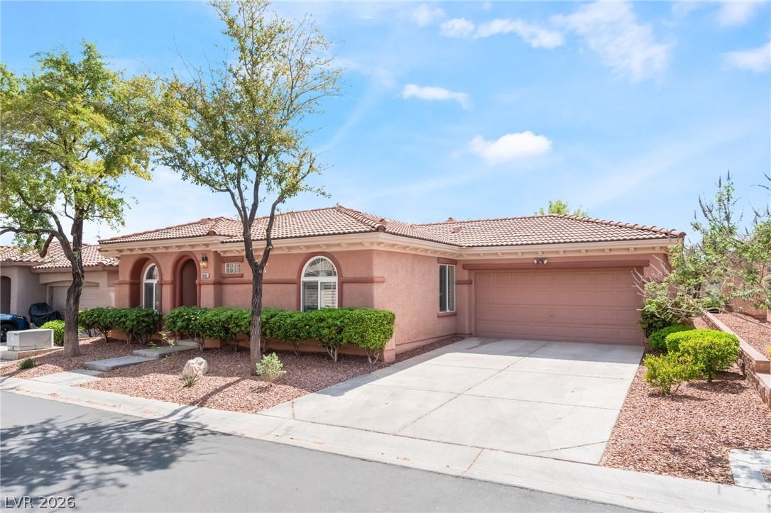 10481 Riverside Park Avenue Las Vegas, NV 89135 - Photo 3 of 51 Mediterranean / spanish house with an attached garage, stucco siding, driveway, and a tile roof