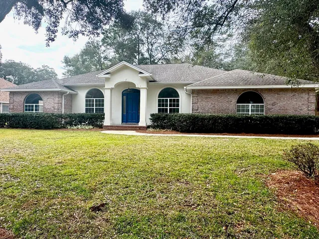 a front view of a house with yard and green space