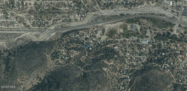 a view of a dry yard with wooden floor and fence
