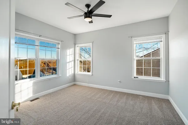 an empty room with windows and closet