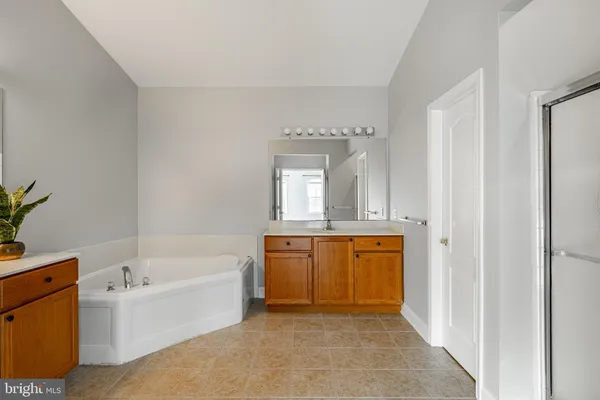 a bathroom with a tub sink and mirror