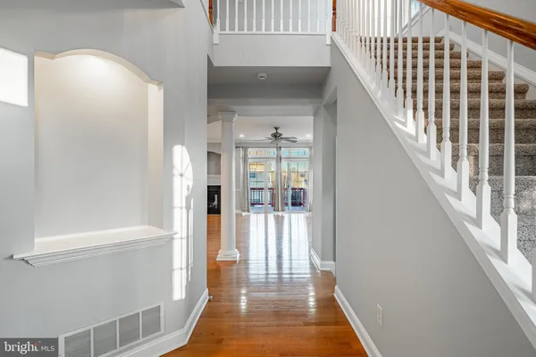 a view of a hallway with wooden floor and staircase
