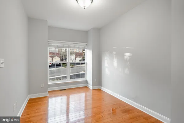 a view of a livingroom with furniture an empty room fire place and windows