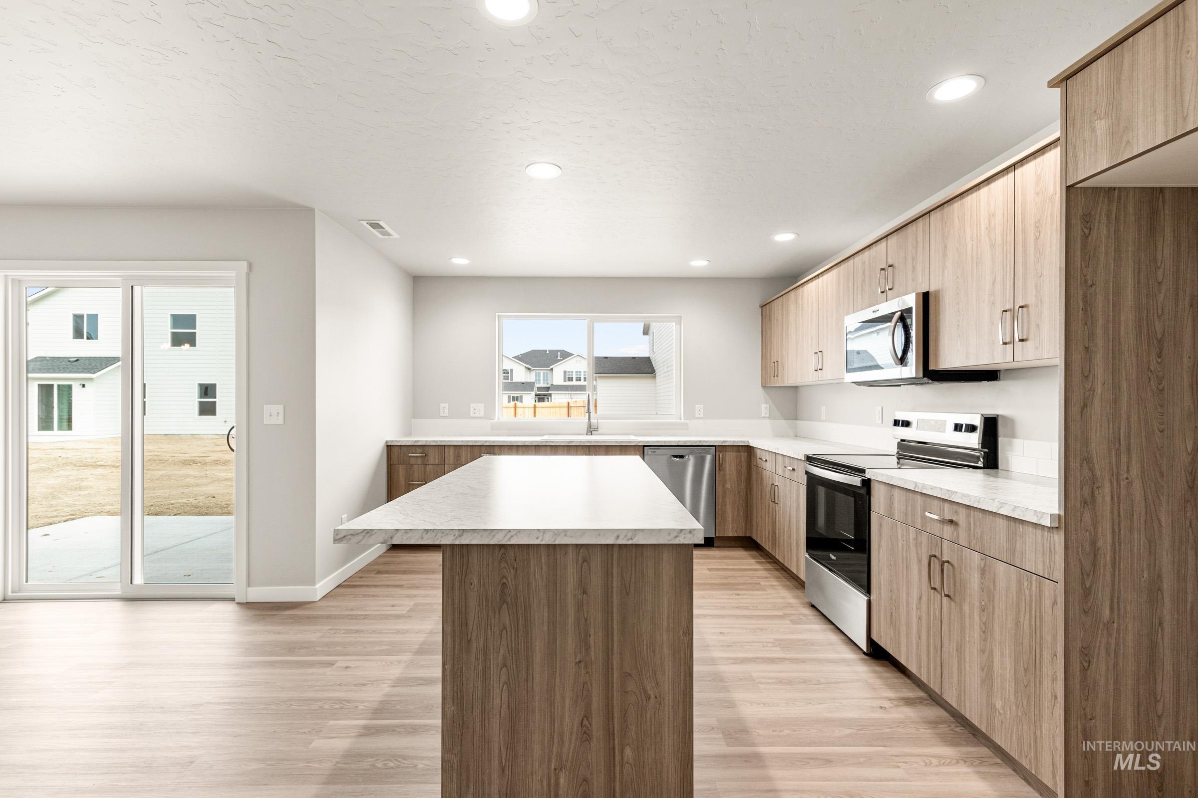 13686 Inman Court Caldwell, ID 83607 - Photo 4 of 20 Kitchen with stainless steel appliances, a center island, light countertops, light wood finished floors, and recessed lighting