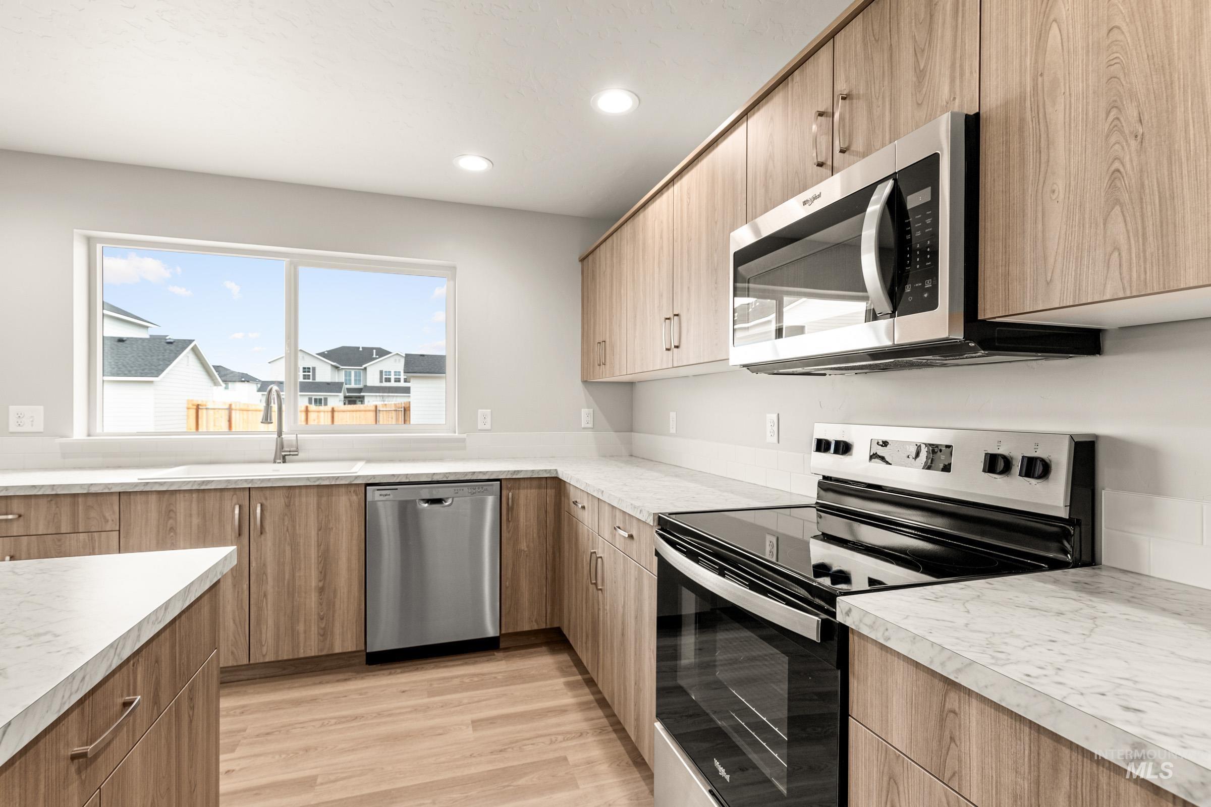 13686 Inman Court Caldwell, ID 83607 - Photo 5 of 20 Kitchen featuring stainless steel appliances, recessed lighting, light wood-style floors, light countertops, and modern cabinets