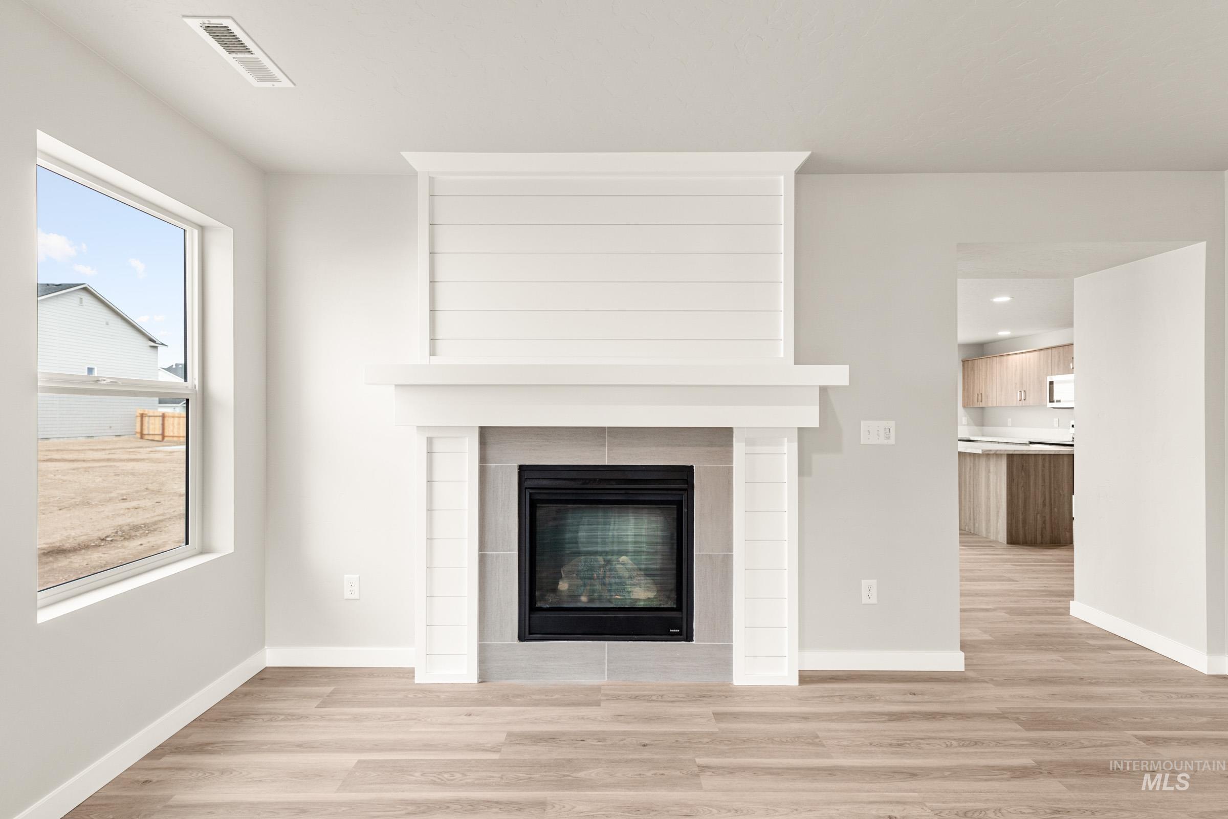 13686 Inman Court Caldwell, ID 83607 - Photo 9 of 20 Detailed view of wood finished floors and a tiled fireplace