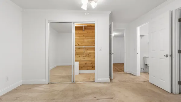 an empty room with closet and windows