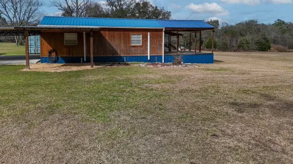 a view of a house with backyard and sitting area