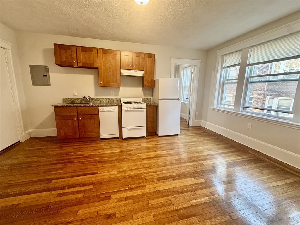 1615 Commonwealth Avenue, Unit 27 Boston, MA 02135 - Photo 2 of 10 a view of a kitchen with wooden floor and a kitchen