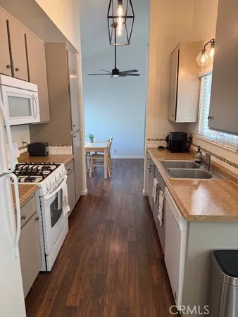 a kitchen with a sink stove and wooden floor