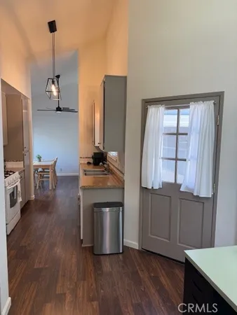 a kitchen with stainless steel appliances granite countertop a refrigerator a stove and a wooden floors