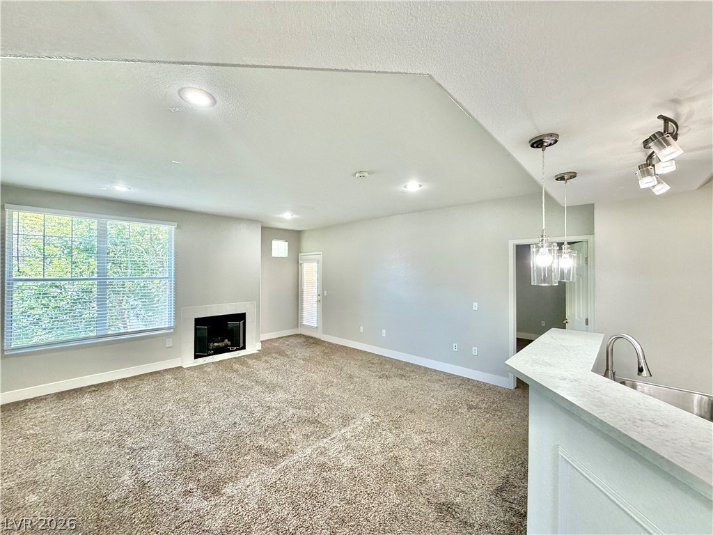 8555 West Russell Road, Unit 2018 Las Vegas, NV 89113 - Photo 10 of 23 A welcoming living space features a cozy fireplace and convenient outdoor access.