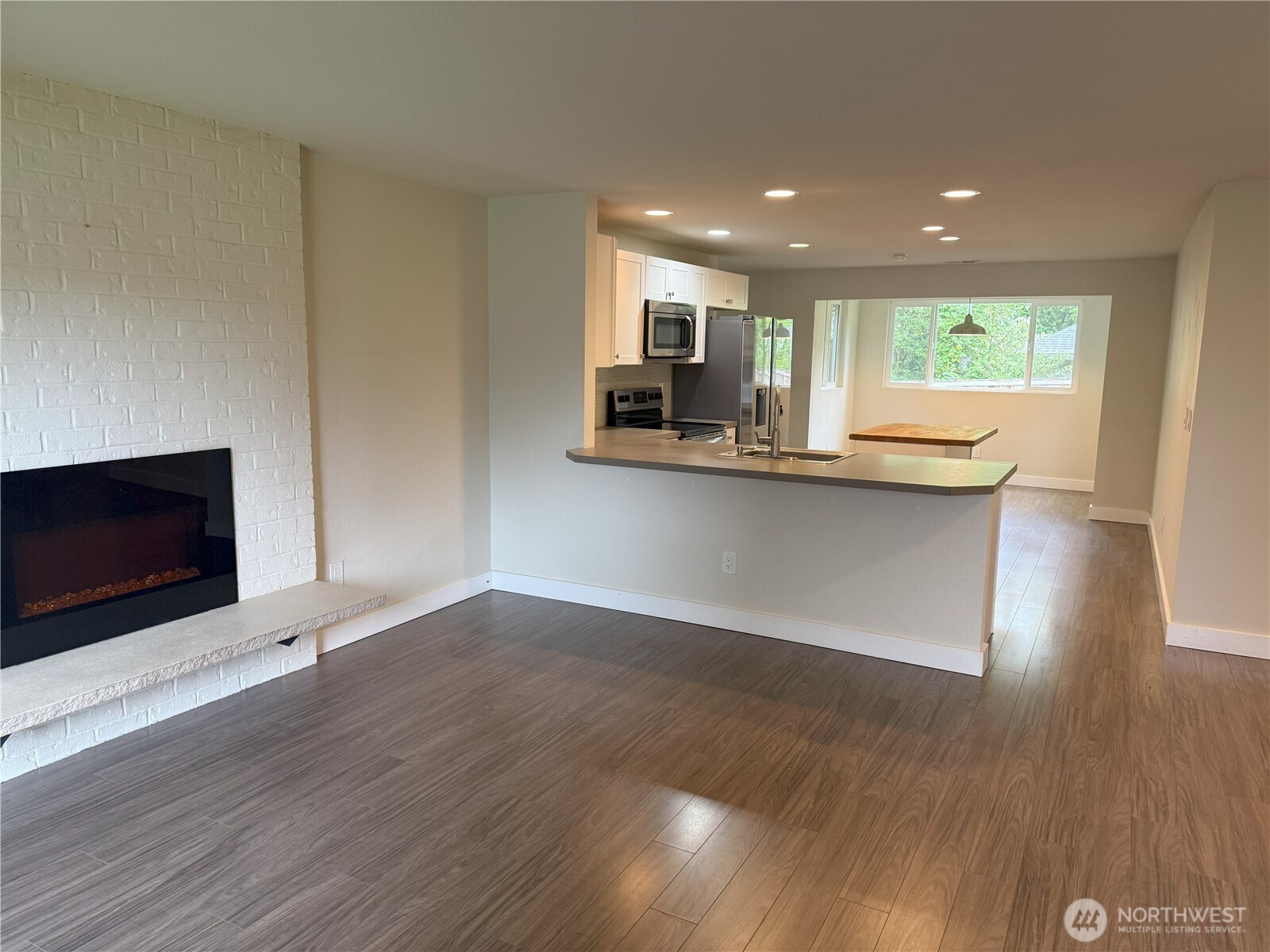 8820 Prentice Avenue Gig Harbor, WA 98332 - Photo 2 of 13 a view of a kitchen with wooden floor and electronic appliances