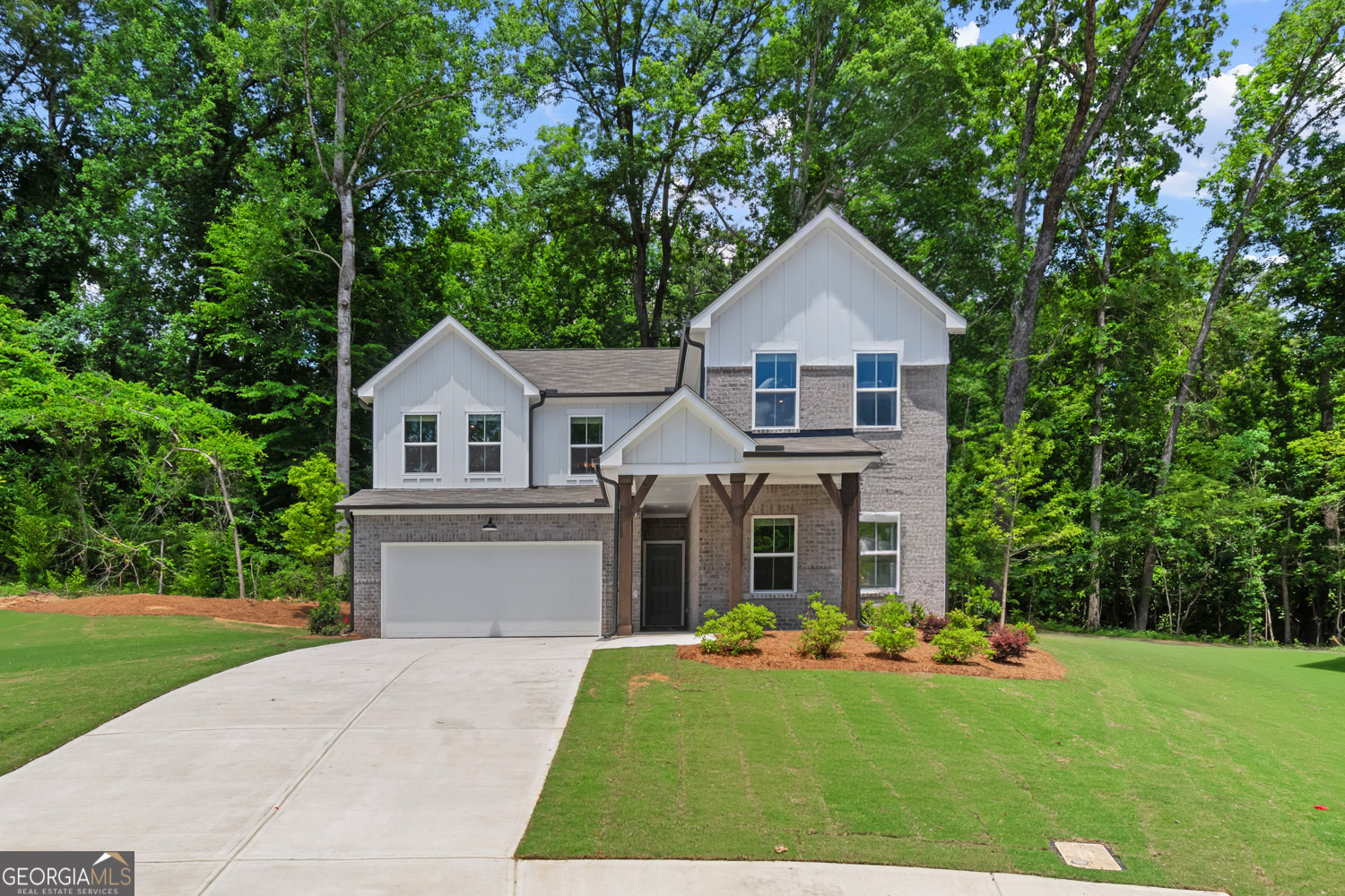 a front view of a house with a yard and trees