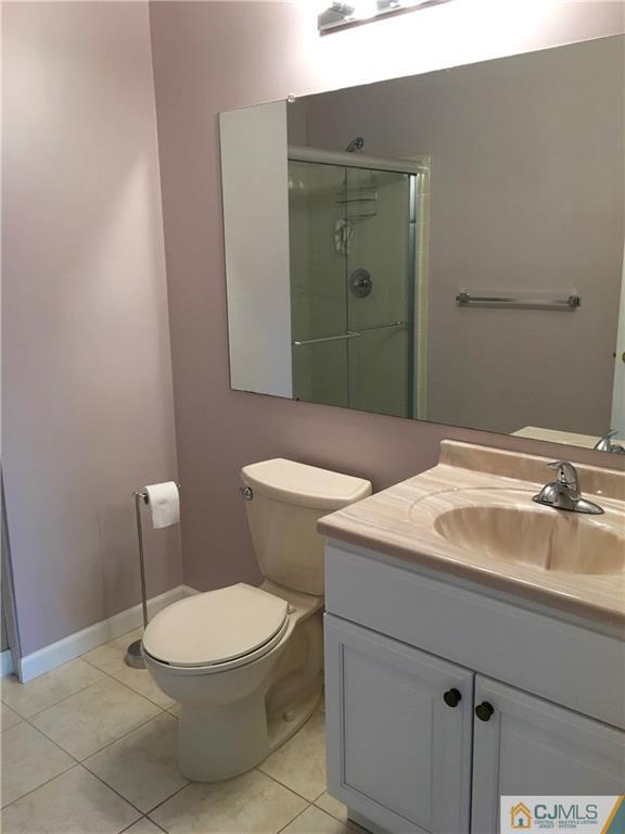313 Wimbeldon Court North Brunswick, NJ 08902 - Photo 15 of 17 a bathroom with a sink a toilet and mirror