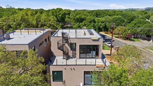 an aerial view of a house with garden space and street view