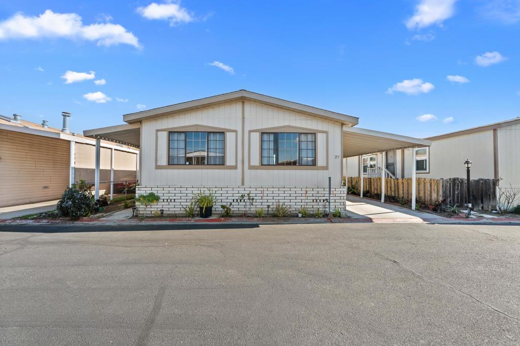 4616 North River Road, Unit 27 Oceanside, CA 92057 - Photo 1 of 1 a front view of a house with yard and parking