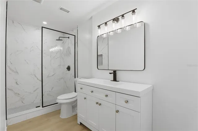 a bathroom with a double vanity sink toilet mirror and shower