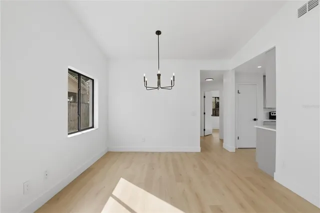 a view of empty room with wooden floor and window