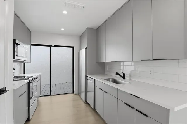 a kitchen with stainless steel appliances a sink stove and refrigerator