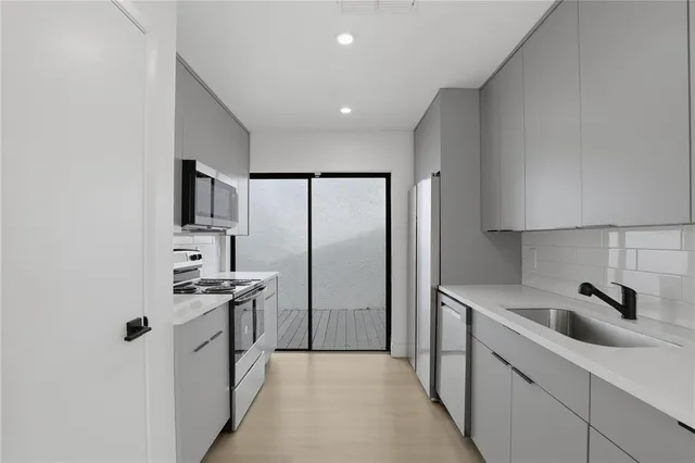 a kitchen with stainless steel appliances granite countertop a sink stove and refrigerator