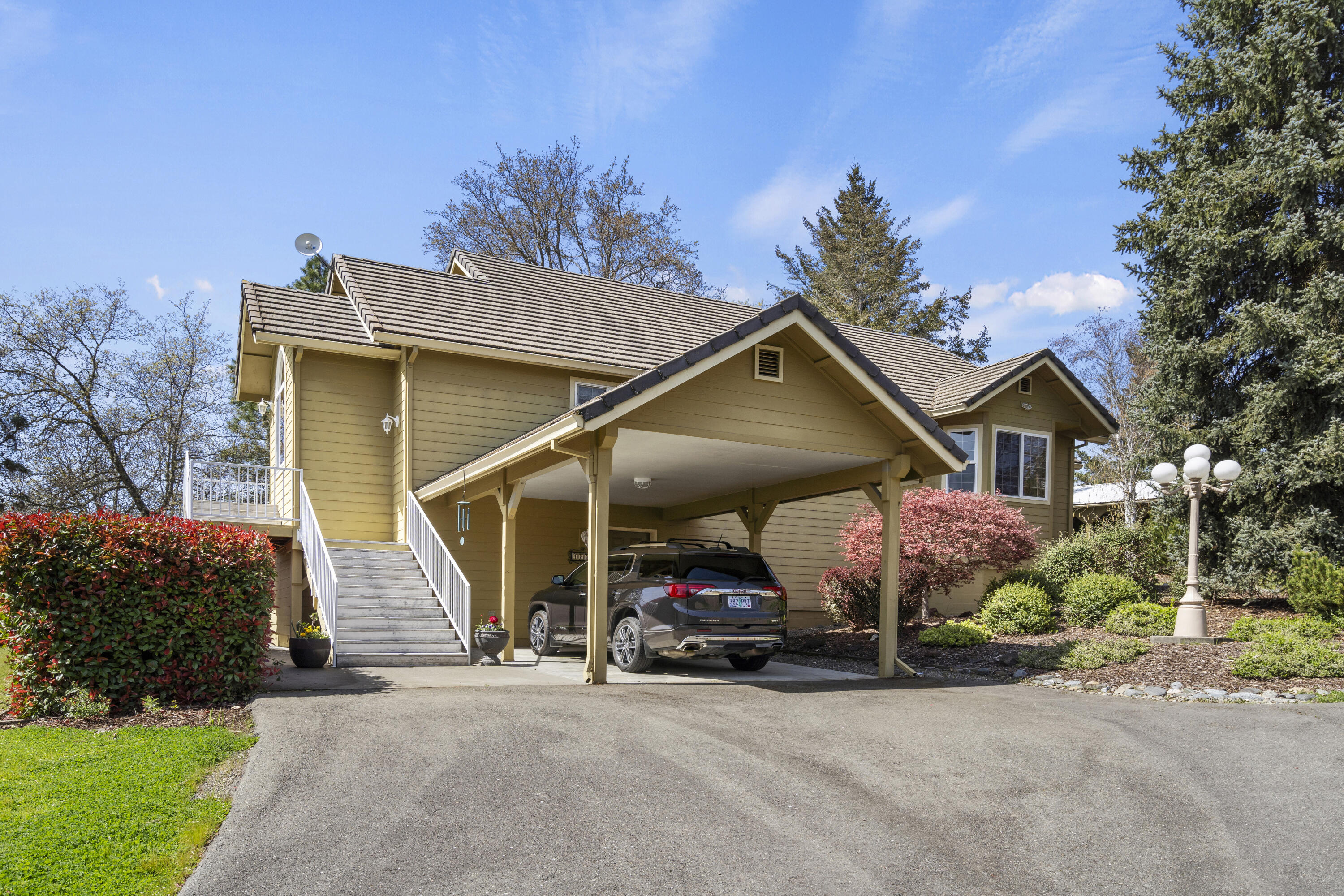 4874 Upper River Road Grants Pass, OR 97526 - Photo 4 of 66 a view of a house with a small yard and a car parked