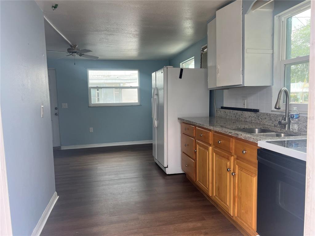 5206 7th Street Zephyrhills, FL 33542 - Photo 3 of 10 a kitchen with stainless steel appliances granite countertop a stove a sink and a refrigerator