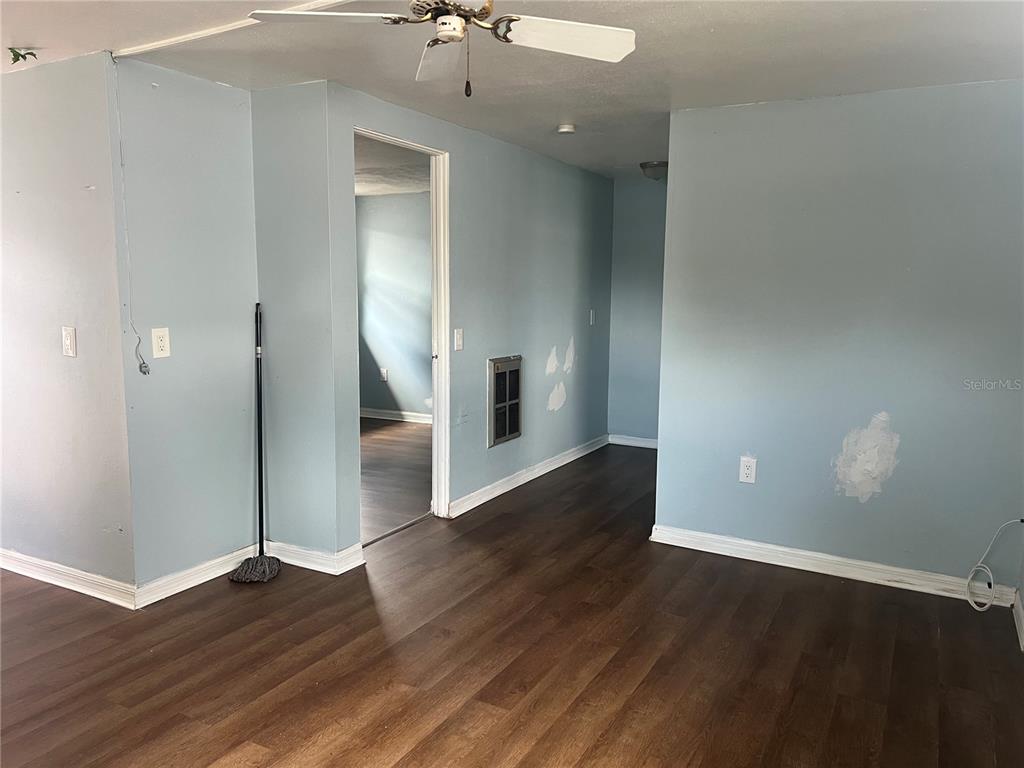 5206 7th Street Zephyrhills, FL 33542 - Photo 4 of 10 an empty room with wooden floor and entrance