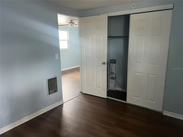 an empty room with wooden floor and closet