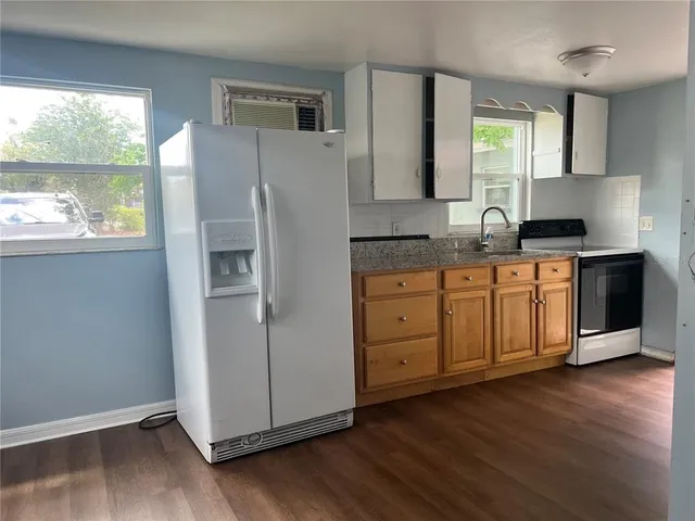 a kitchen with a refrigerator sink and cabinets