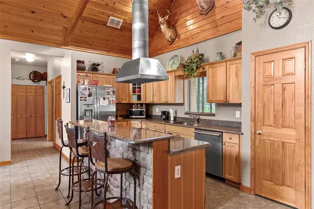 a kitchen with stainless steel appliances granite countertop a sink and a refrigerator